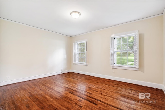 spare room featuring crown molding and hardwood / wood-style flooring