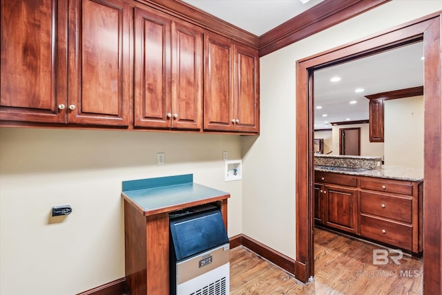 washroom featuring crown molding, light hardwood / wood-style flooring, cabinets, and washer hookup