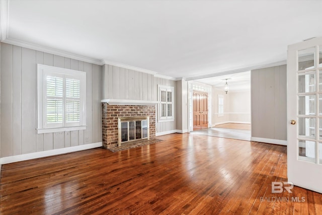 unfurnished living room featuring wood-type flooring, a fireplace, and ornamental molding