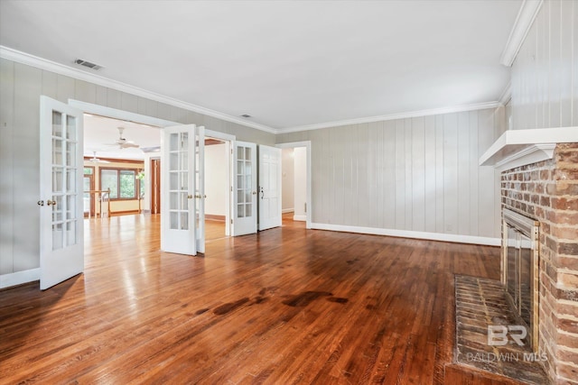 unfurnished living room featuring a fireplace, french doors, hardwood / wood-style floors, and ornamental molding