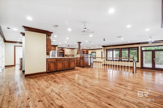 kitchen featuring ceiling fan, stainless steel fridge, ornamental molding, light hardwood / wood-style floors, and light stone counters