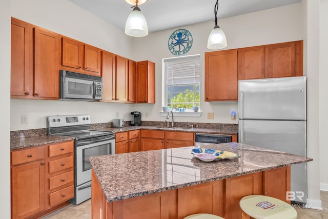 1430 Regency Rd Unit G101, Gulf Shores, AL 36542 - kitchen featuring stainless steel appliances, a kitchen breakfast bar, dark stone counters, and hanging light fixtures