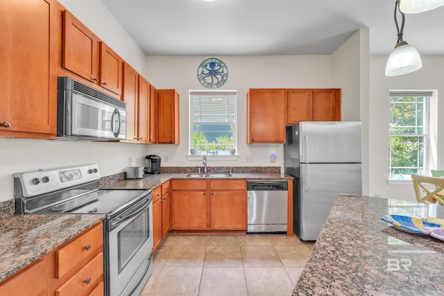 1430 Regency Rd Unit G101, Gulf Shores, AL 36542 - kitchen featuring stainless steel appliances, dark stone countertops, hanging light fixtures, and brown cabinets