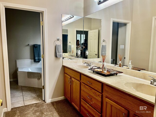 bathroom with tile patterned flooring, vanity, and a bath