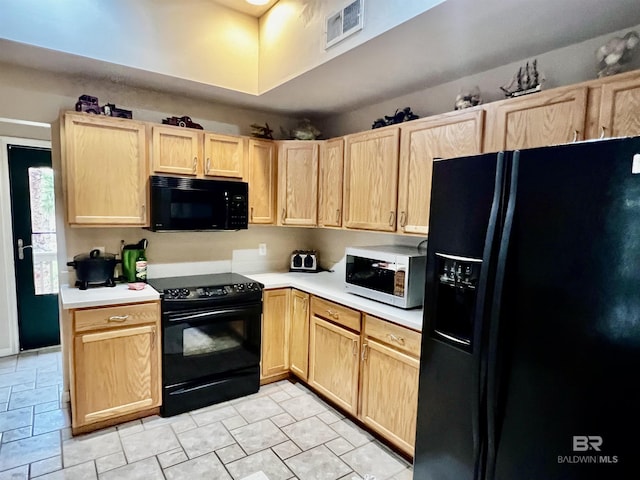 kitchen with light brown cabinets and black appliances