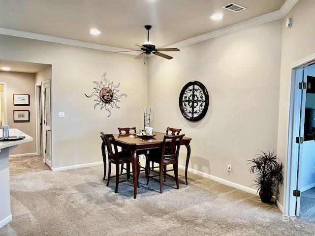 dining area with light colored carpet, ceiling fan, and ornamental molding