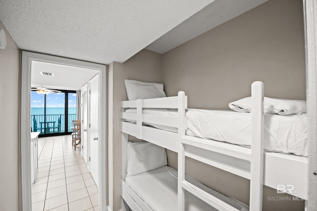533 W Beach Blvd Unit 602, Gulf Shores, AL 36542 - bedroom with tile patterned flooring, a textured ceiling, visible vents, and a wall of windows