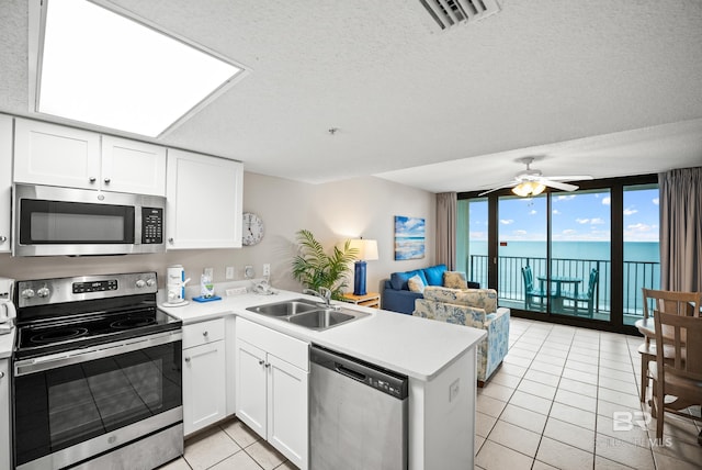 533 W Beach Blvd Unit 602, Gulf Shores, AL 36542 - kitchen with a sink, a wall of windows, a peninsula, appliances with stainless steel finishes, and visible vents