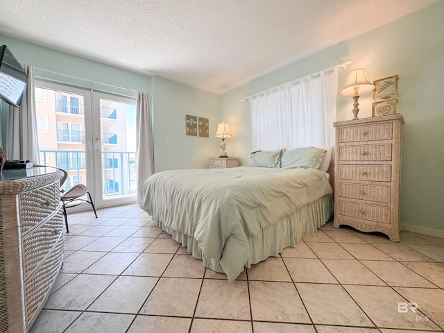 bedroom with french doors, a textured ceiling, light tile patterned floors, and access to exterior