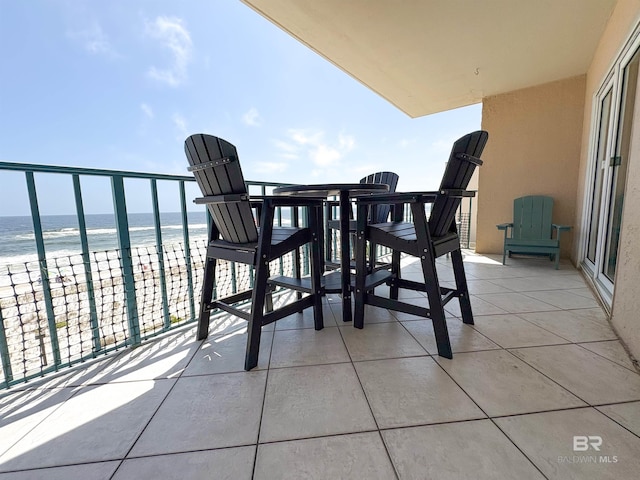 balcony featuring a view of the beach and a water view