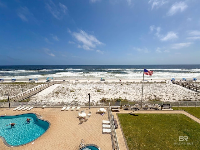 view of water feature featuring a view of the beach and fence