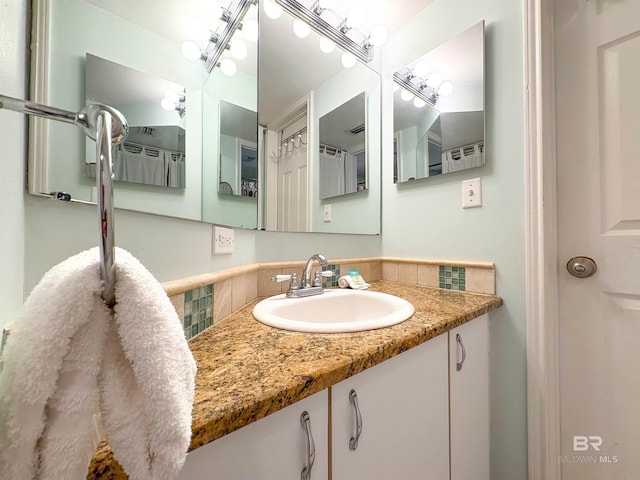 bathroom with vanity and decorative backsplash