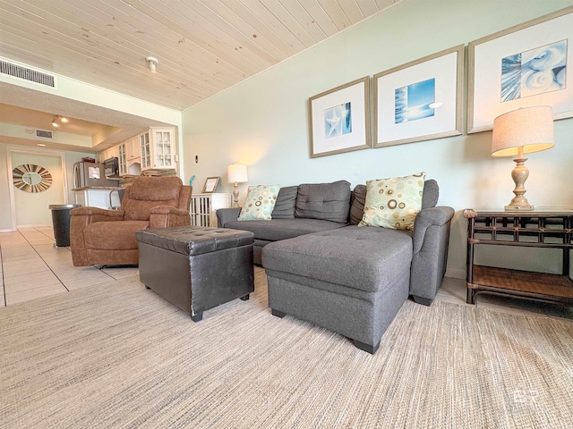 living area with wooden ceiling, visible vents, and light colored carpet