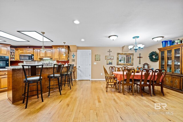 dining area with an inviting chandelier and light hardwood / wood-style floors