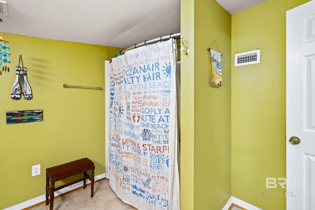 bathroom featuring curtained shower and tile patterned floors