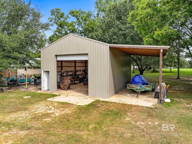 view of outdoor structure with a lawn, a garage, and a carport