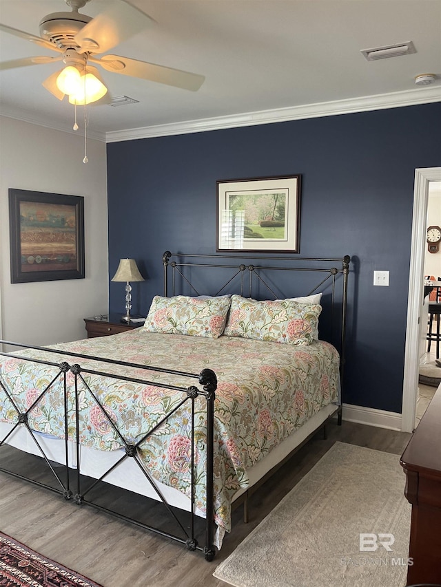 bedroom with ceiling fan, wood-type flooring, and crown molding