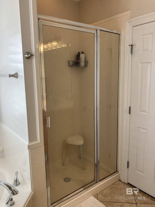 bathroom with tile patterned flooring and separate shower and tub