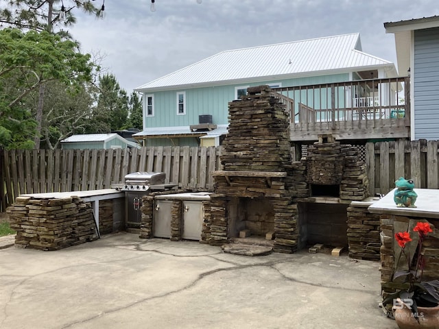 view of patio with a wooden deck, grilling area, and an outdoor stone fireplace