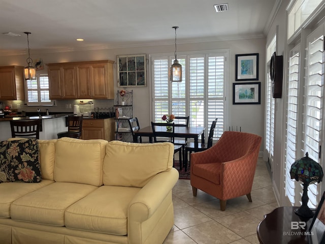 living room with sink, light tile patterned floors, and crown molding