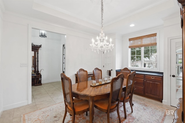 dining area with crown molding, light tile patterned floors, a chandelier, and a tray ceiling