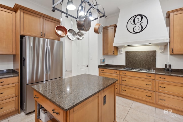 kitchen featuring custom exhaust hood, hanging light fixtures, dark stone counters, ornamental molding, and stainless steel appliances