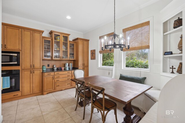 dining area featuring crown molding, light tile patterned floors, an inviting chandelier, and breakfast area