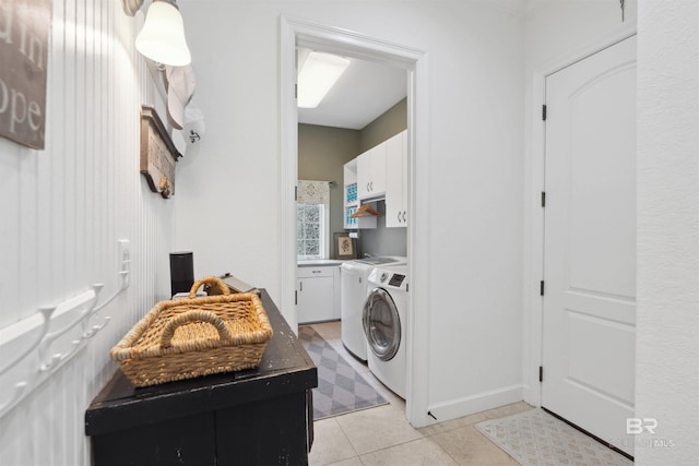 laundry area with cabinets, washer and clothes dryer, and light tile patterned floors