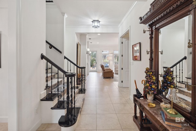 tiled entryway featuring crown molding