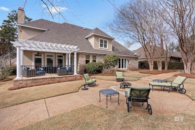 rear view of house featuring a patio, a pergola, a lawn, and a fire pit