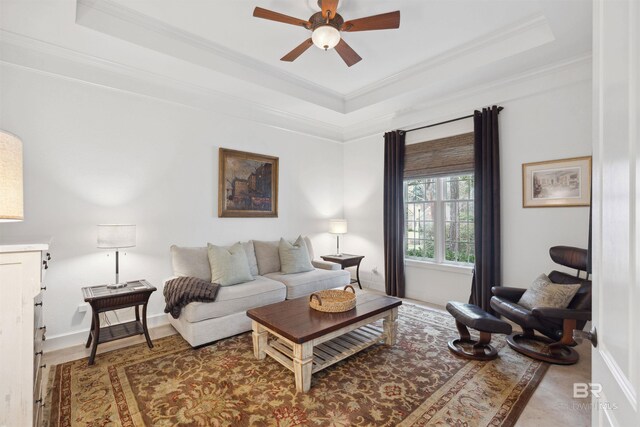 living room featuring crown molding, ceiling fan, and a tray ceiling