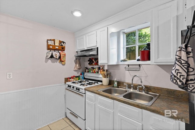 162 Westwood St, Mobile, AL 36606 - kitchen featuring white gas range oven, a sink, under cabinet range hood, a wainscoted wall, and white cabinets