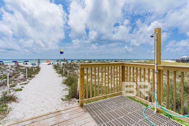 deck featuring a view of the beach and a water view