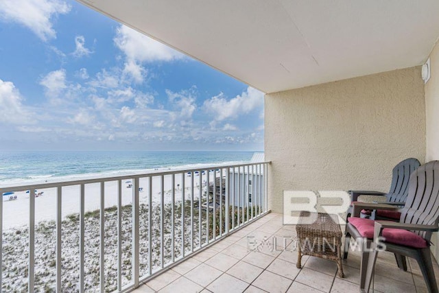 balcony featuring a view of the beach and a water view