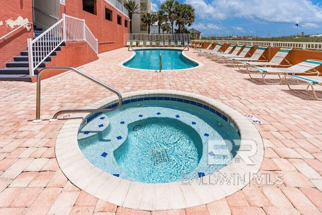 view of pool with a patio area and a hot tub