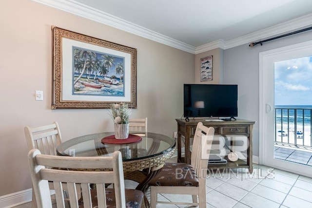 dining room with a water view, ornamental molding, and light tile floors