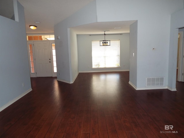 foyer with baseboards, visible vents, and dark wood-type flooring