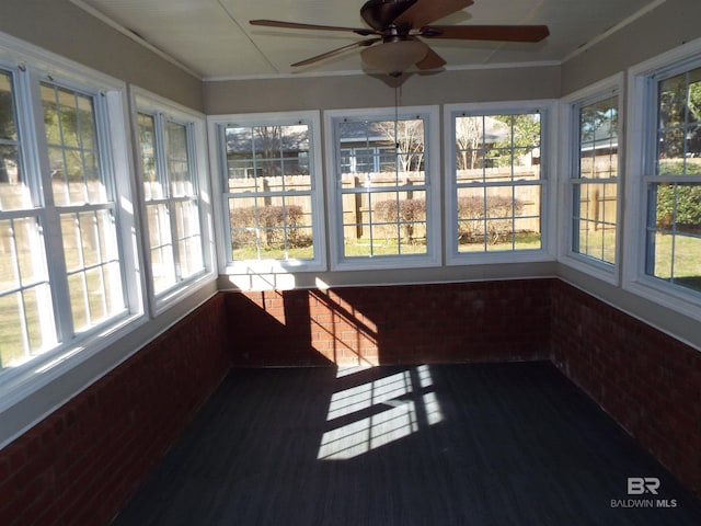 unfurnished sunroom with ceiling fan