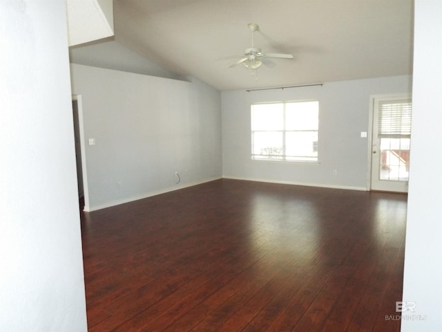 spare room with baseboards, a ceiling fan, vaulted ceiling, and dark wood-type flooring