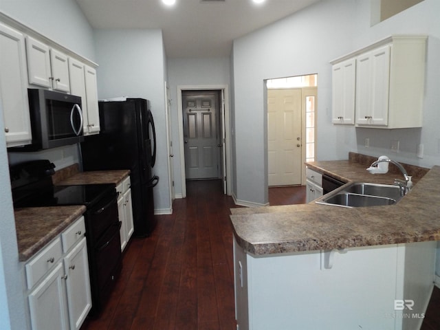 kitchen with dark countertops, white cabinetry, a sink, a peninsula, and black appliances