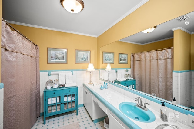 56 Old Bratt Rd, Atmore, AL 36502 - bathroom featuring double vanity, tile walls, crown molding, wainscoting, and tile patterned floors