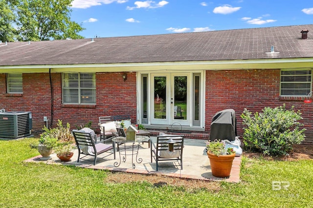 56 Old Bratt Rd, Atmore, AL 36502 - back of house with central air condition unit, brick siding, roof with shingles, a lawn, and a patio area