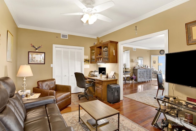 living room featuring visible vents, crown molding, ceiling fan, and wood finished floors