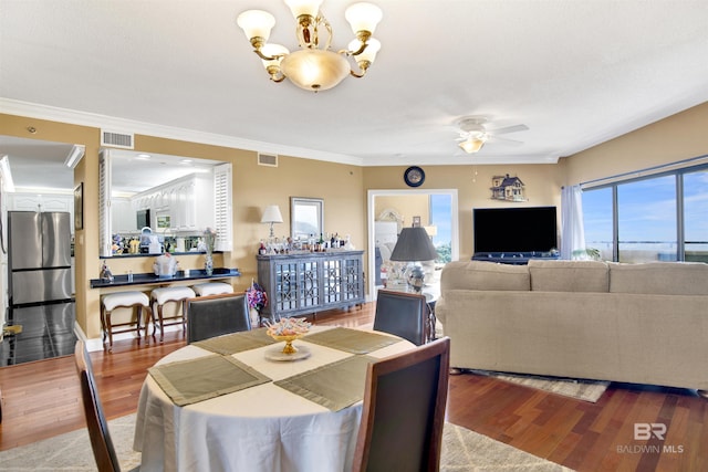 dining room with visible vents, a healthy amount of sunlight, and wood finished floors