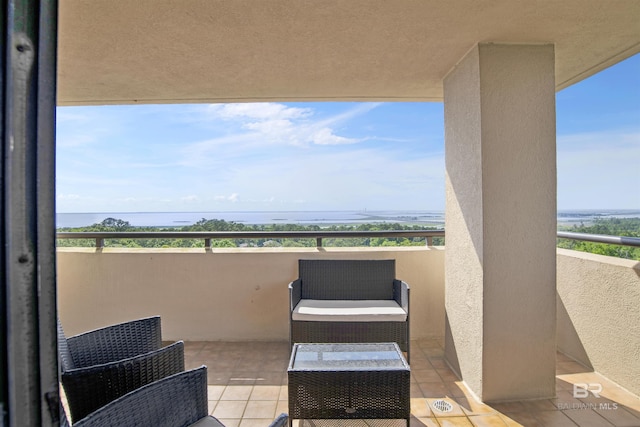 view of patio with a water view and a balcony