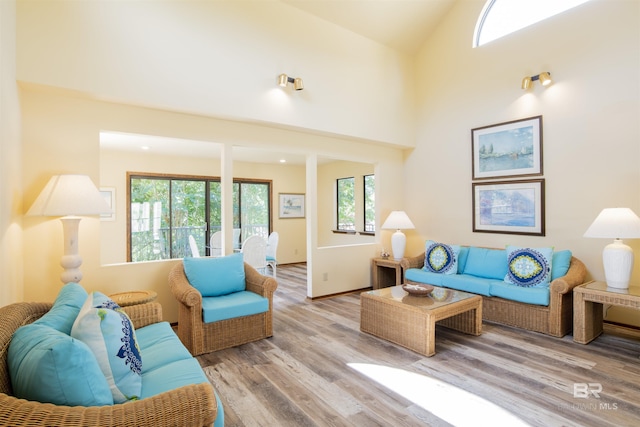 living area featuring vaulted ceiling, a wealth of natural light, and wood finished floors