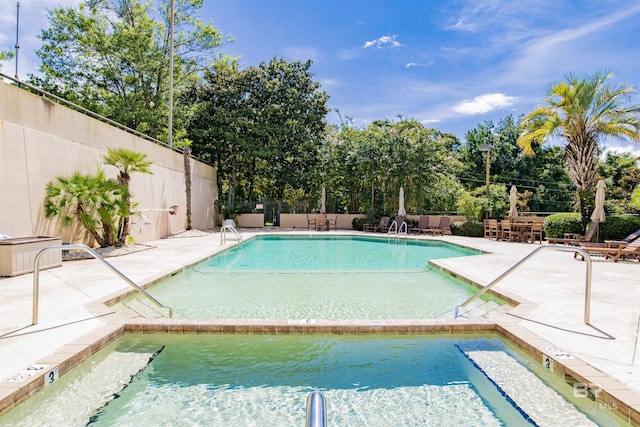 pool with a patio area and fence