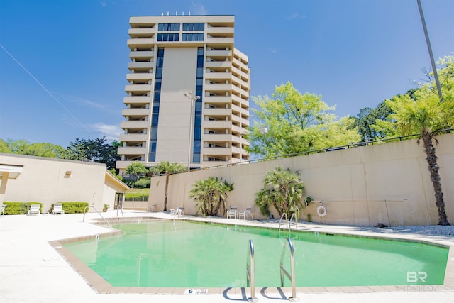 pool featuring fence and a patio area