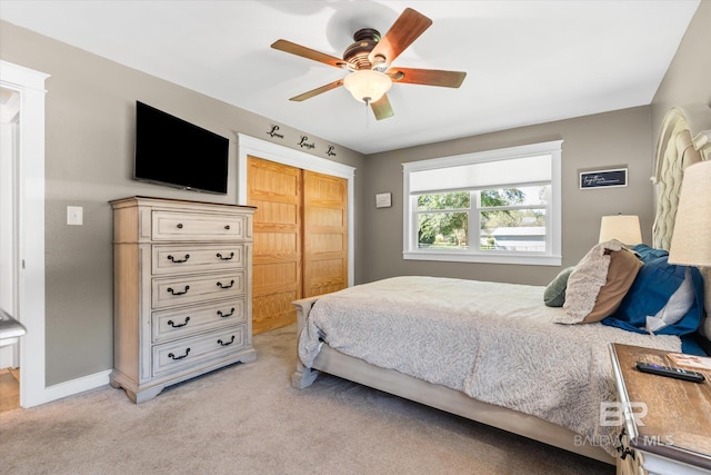 carpeted bedroom featuring ceiling fan and a closet