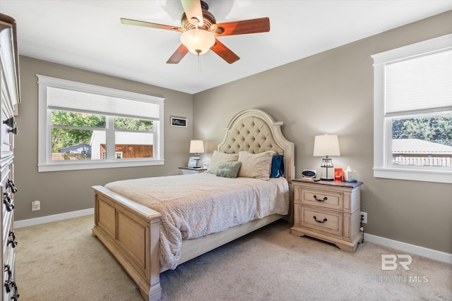 carpeted bedroom with ceiling fan and multiple windows